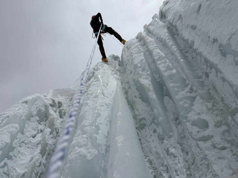 A climber on a steep icy ridge high in the Himalayas