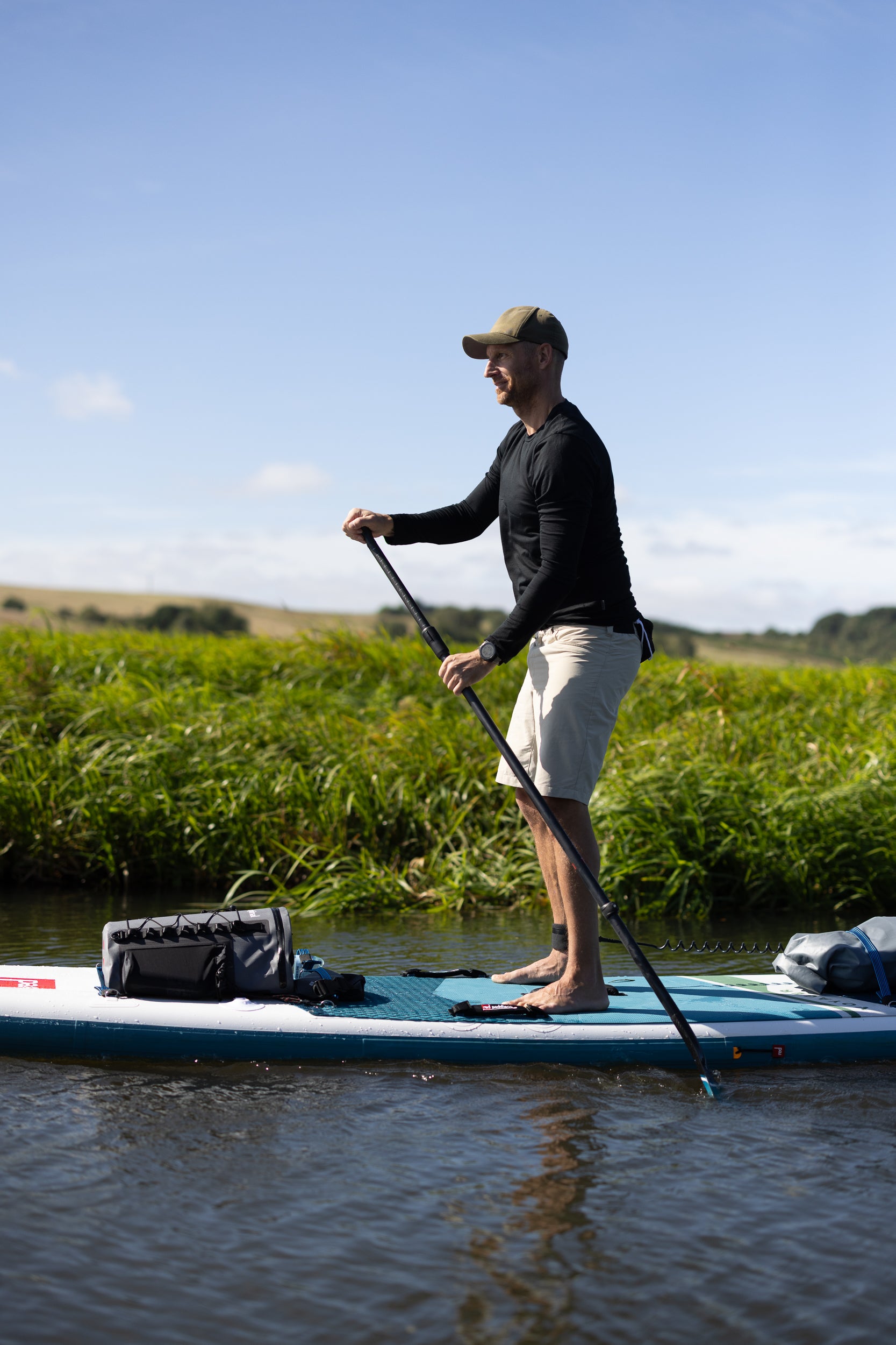 Anders Lorentzen paddling a SUP board in a black LOOW merino long sleeve